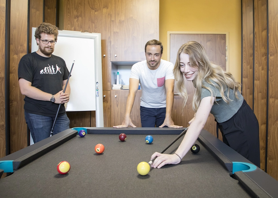 Photo de nos employés partageant un moment de vie autour du billard